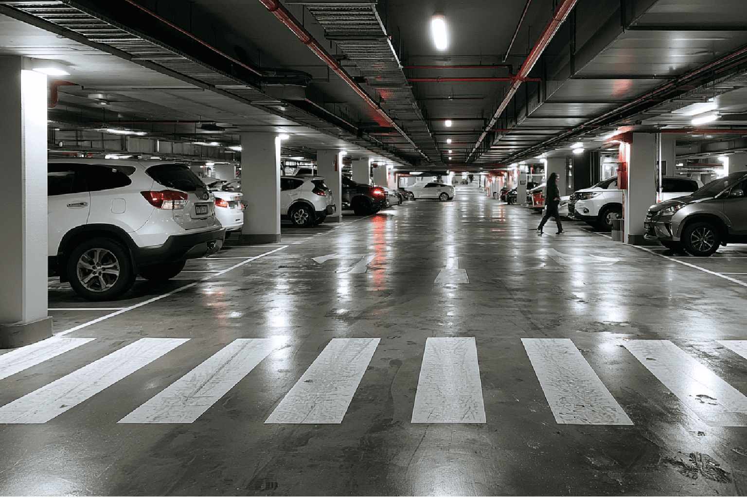 Underground shopping centre car park showing pedestrian crossing and damp floor conditions highlighting slip risk